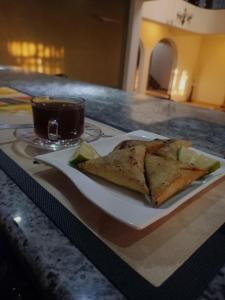 einen Teller Essen auf einem Tisch mit einer Tasse Kaffee in der Unterkunft Mojoh Inn Hotel in Ambira