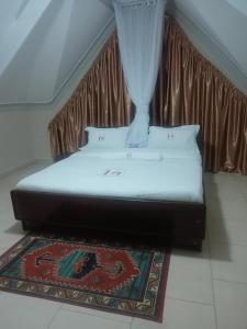Bett in einem Zimmer mit Vorhang in der Unterkunft Mojoh Inn Hotel in Ambira