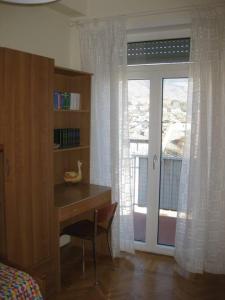 a bedroom with a desk and a door with a window at Aosta centro storico e splendida vista panoramica in Aosta