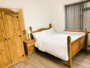 a bedroom with a bed with white sheets and a window at Peaceful - 4 bedroom House in Earley