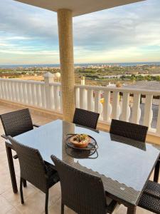 una mesa y sillas en un balcón con vistas en Villa con vistas al mar en Alicante