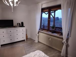 a bedroom with a dresser and a window at Breakfast in bed in Hörschhausen