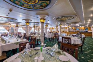 a dining room on a train with tables and chairs at MS Chateau Lafayette Nile Cruise - 4 nights from Luxor each Monday and 3 nights from Aswan each Friday in Luxor