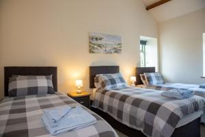 two beds sitting in a room with two lamps at Stables Cottage in Selby