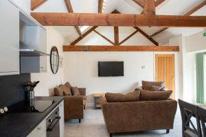 a kitchen and living room with wooden ceilings at Stables Cottage in Selby