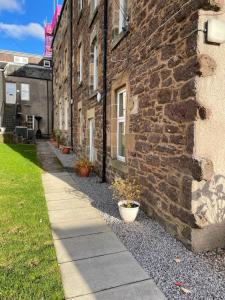 a stone building with a sidewalk next to a building at Stunning Apartment in Callander in Callander