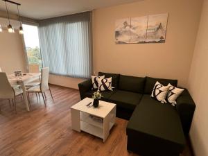 ein Wohnzimmer mit einem Sofa und einem Tisch in der Unterkunft Апартамент Комфорт 2 Близо до Летището in Sofia