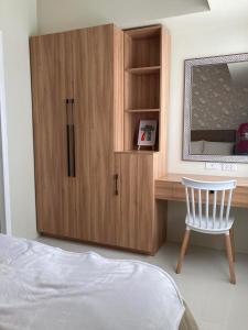 a bedroom with a wooden cabinet and a chair at Brenthill Condominium in Baguio