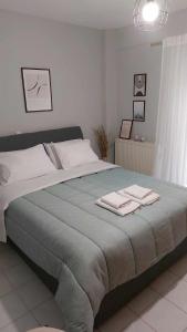 a bedroom with a large bed with two towels on it at Hermes Modern Apartment in Alexandroupoli
