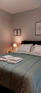 - une chambre avec un grand lit et des serviettes dans l'établissement Hermes Modern Apartment, à Alexandroúpolis