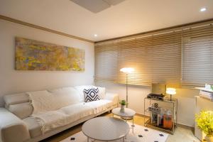un soggiorno con un divano bianco e un tavolo di Free pick-up, 4 Beds, near Gangnam, Hongdae, Subway 8 mins, Spacious a Seul Altre 27 foto