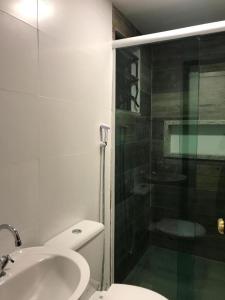a bathroom with a shower and a toilet and a sink at AIPA HOSTEL.COM in Cabo Frio