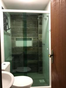 a bathroom with a glass shower with a toilet at AIPA HOSTEL.COM in Cabo Frio