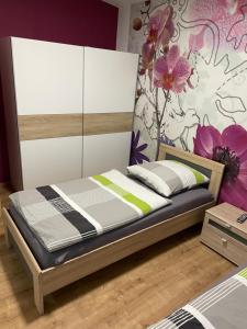 a bedroom with a bed with a flower wall at Ferienwohnung Meiwes in Hövelhof