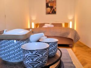 two blue and white vases on a table with a bed at CozyHome Medena Central, quiet premium spot in Old Town in Bratislava