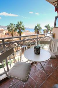 a table and chairs on a balcony with palm trees at Coral Compostela Beach in Arona