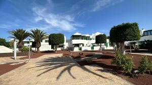 un groupe de maisons blanches avec des arbres et un trottoir dans l'établissement CASA OASI, à Playa Blanca