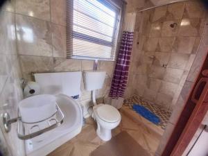 a bathroom with a toilet and a shower at Sally's Tranquil Airbnb in Centurion