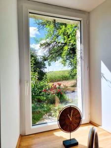 eine Uhr, die vor einem großen Fenster sitzt in der Unterkunft Le Cottage 