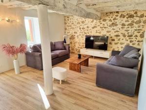 ein Wohnzimmer mit 2 Sofas und einem Flachbild-TV in der Unterkunft Le Cottage 