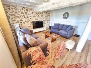 ein Wohnzimmer mit einem Sofa und einem TV in der Unterkunft Le Cottage 