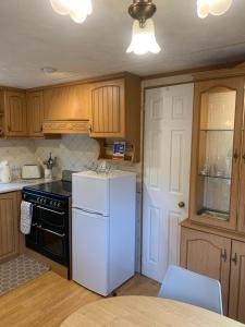 a kitchen with a white refrigerator and a table at Farm stay caravan on working farm in Dacre