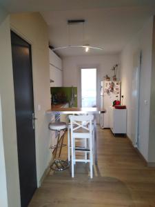 uma cozinha com um balcão e um banco num quarto em Appartement confortable centre ville em LʼIsle-sur-la-Sorgue
