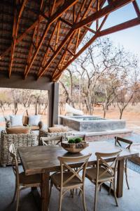 a patio with a wooden table and chairs at Minara Private Boutique Game Lodge in Dinokeng Game Reserve
