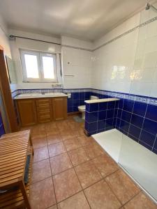 bagno piastrellato blu con lavandino e servizi igienici di Casa Triana a Soure