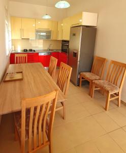 kuchnia z drewnianym stołem i krzesłami oraz lodówką w obiekcie Luxury Penthouse w mieście Široki Brijeg