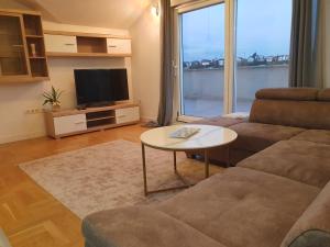 a living room with a couch and a table at Luxury Penthouse in Široki Brijeg
