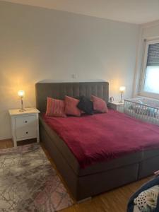 a bedroom with a large bed with red sheets at Mobilierte 5 Zimmer Wohnung zur vermieten in Frankfurt