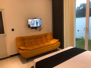 a living room with a couch and a flat screen tv at Luvi’s Villa in Galle