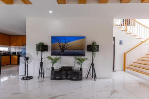 sala de estar con TV en una pared con plantas en Cozy crib in Saratoga with Jacuzzi, en Tagaytay