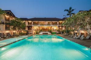 a swimming pool in front of a building at Loman Park Hotel Yogyakarta in Yogyakarta