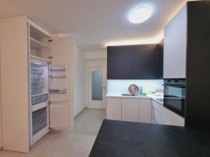 una cucina con armadi bianchi e frigorifero vuoto di FR Residence a Prizren