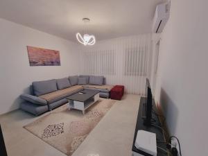 un soggiorno con divano blu e tavolo di FR Residence a Prizren
