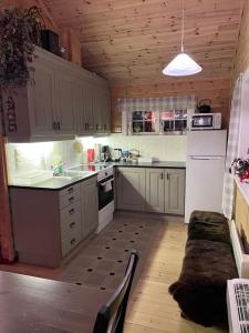 a kitchen with white appliances and a wooden ceiling at Domek Iwony in Molde