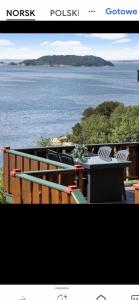 a table and chairs on a deck with a view of the water at Domek Iwony in Molde