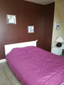 een bed met een paars dekbed in een slaapkamer bij Villa Face Mer in Audresselles