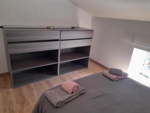 a bedroom with a bed and a dresser with two pillows at il fait bon vivre classé 3 étoiles in Montcuq