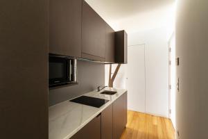 a kitchen with brown cabinets and a counter top at Pensao O Laranjeira in Viana do Castelo