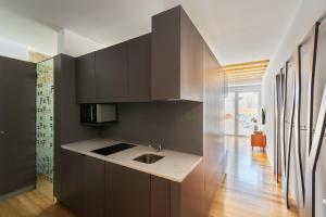 a kitchen with black cabinets and a sink at Pensao O Laranjeira in Viana do Castelo