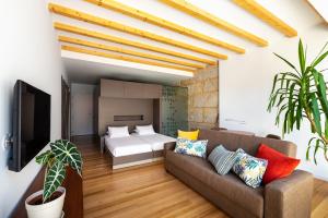 a living room with a couch and a bed at Pensao O Laranjeira in Viana do Castelo