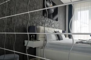 una camera con letto e specchio di Elite Penthouse - Netflix free a Braşov