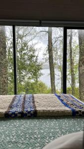 a bed in a room with a large window at Tiny House & Loft House in Panguipulli