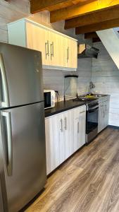 a kitchen with a stainless steel refrigerator and wooden cabinets at Tiny House & Loft House in Panguipulli