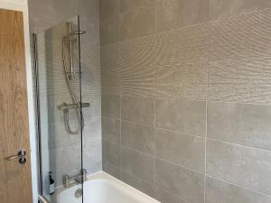 a bathroom with a shower and a bath tub at Stunning Apartment in Callander in Callander