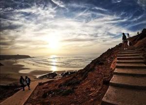 eine Gruppe von Menschen, die die Treppe zum Strand hinaufgehen in der Unterkunft Mirleft Tayought Guest House in Mirleft