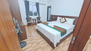 a bedroom with a bed and a room with a fan at Family Transit Hotel in Thach Loi